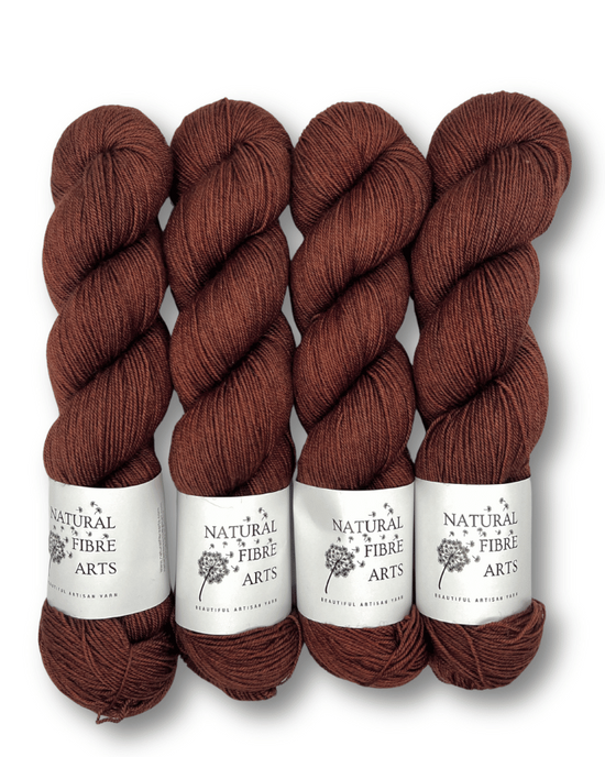 Four skeins of brown yarn with labels on a white background