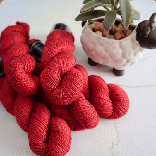 Hand dyed yarn. Richly saturated warm red, semi solid, hand dyed yarn on Merino Silk Yak fingering weight 4 ply yarn.
