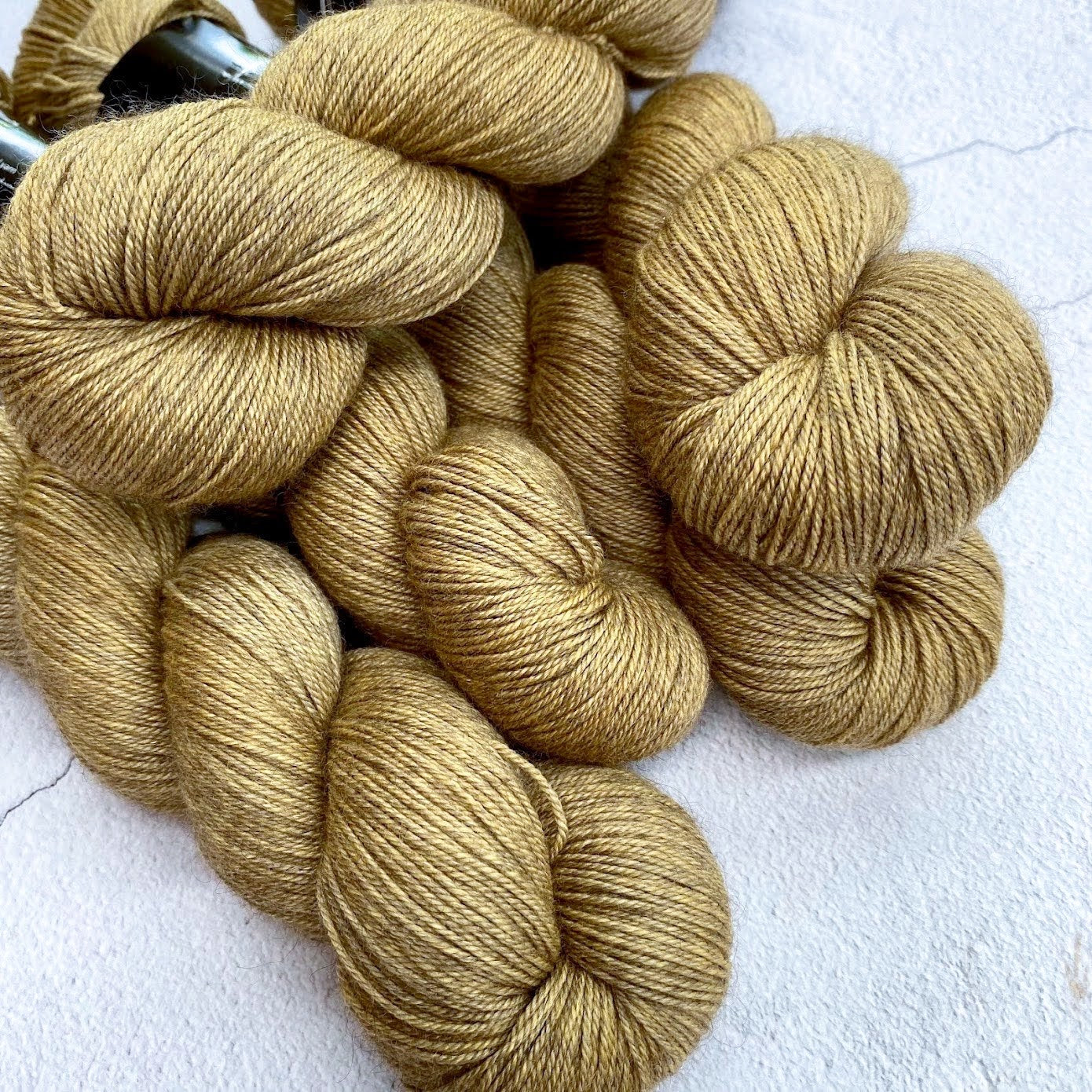 Hand dyed yarn. Medium gold, semi solid, hand dyed yarn on Merino Silk Yak fingering weight 4 ply yarn.