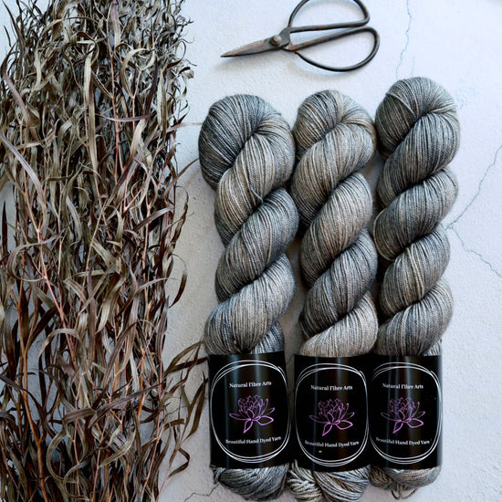 Hand dyed yarn. Pale grey and gold with touches of light denim blue, variegated, hand dyed yarn on Merino Silk Yak fingering weight 4 ply yarn.